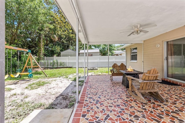 833 Lucerne Cir, Ormond Beach, FL 32174 - fenced backyard featuring an outdoor fire pit, a playground, a ceiling fan, and a patio area