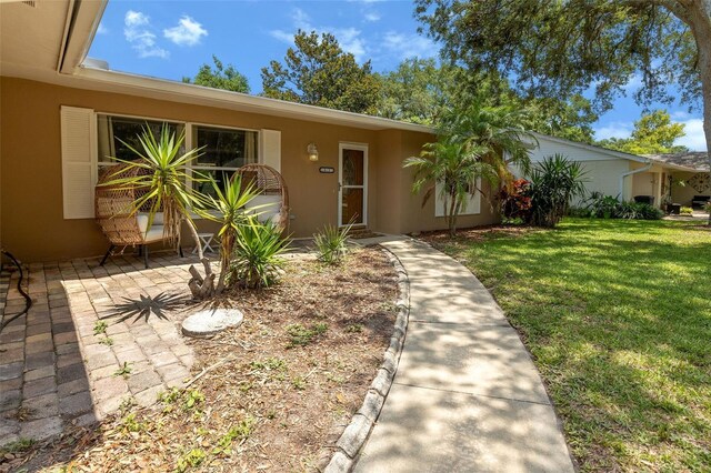 833 Lucerne Cir, Ormond Beach, FL 32174 - view of front facade with a front lawn, stucco siding, and a patio