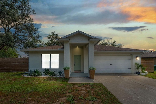 1092 Gage Ave, Deltona, FL 32738 - view of front of home featuring stucco siding, an attached garage, driveway, and a shingled roof