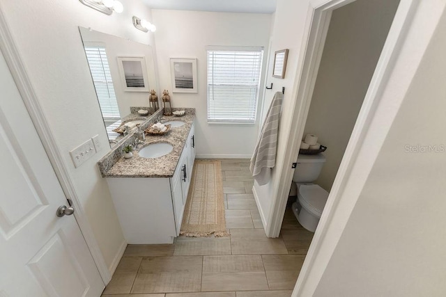 1092 Gage Ave, Deltona, FL 32738 - bathroom featuring double vanity, toilet, baseboards, and tile patterned flooring