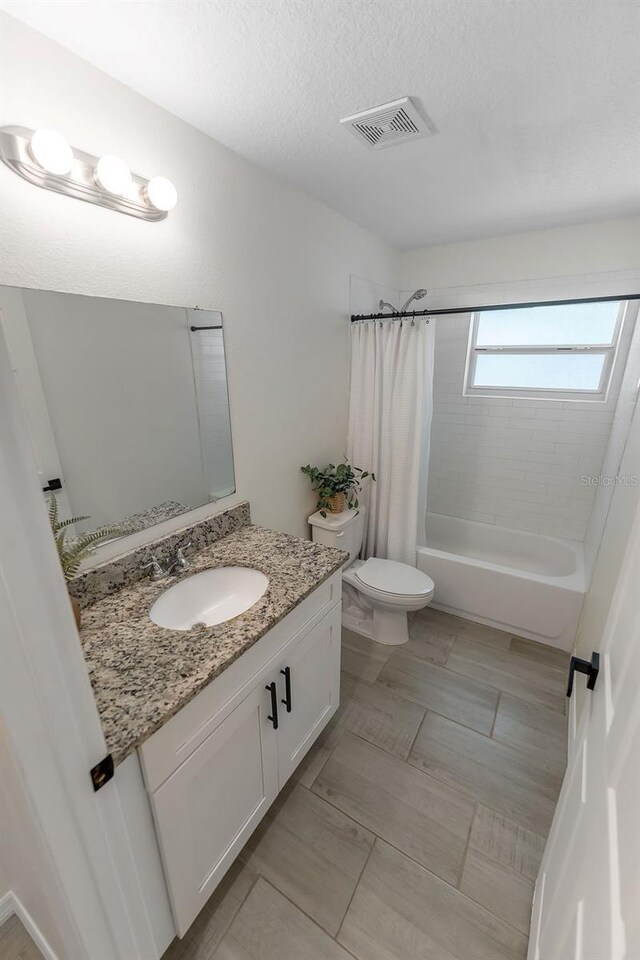 1092 Gage Ave, Deltona, FL 32738 - bathroom featuring vanity, toilet, shower / bath combo, and a textured ceiling