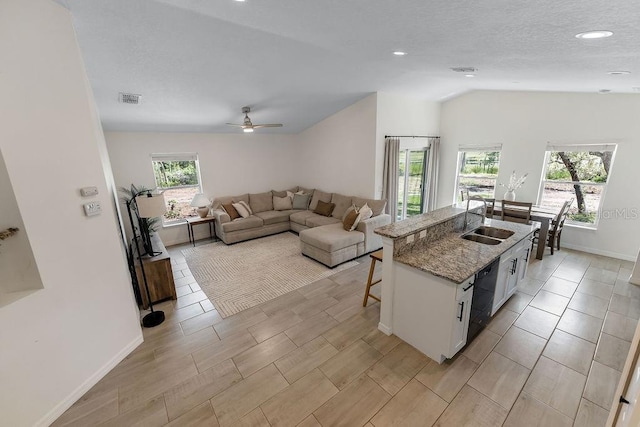 1092 Gage Ave, Deltona, FL 32738 - kitchen featuring a sink, a breakfast bar, white cabinets, light stone counters, and vaulted ceiling