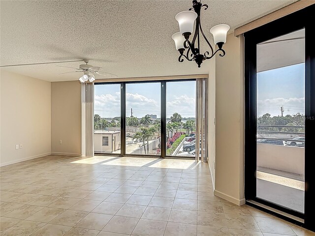 1 Oceans W Blvd Unit 2A1, Daytona Beach, FL 32118 - empty room featuring light tile patterned floors, a textured ceiling, a chandelier, a ceiling fan, and baseboards