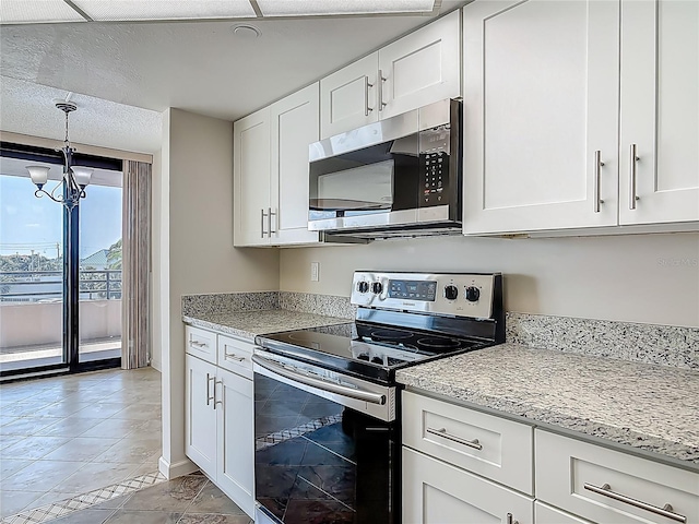 1 Oceans W Blvd Unit 2A1, Daytona Beach, FL 32118 - kitchen featuring appliances with stainless steel finishes, a chandelier, white cabinets, and light stone counters