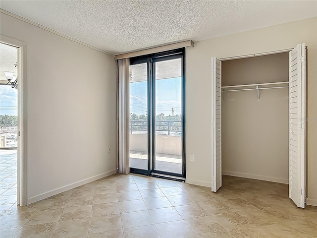 1 Oceans W Blvd Unit 2A1, Daytona Beach, FL 32118 - unfurnished bedroom featuring access to outside, a textured ceiling, multiple windows, a closet, and light tile patterned flooring