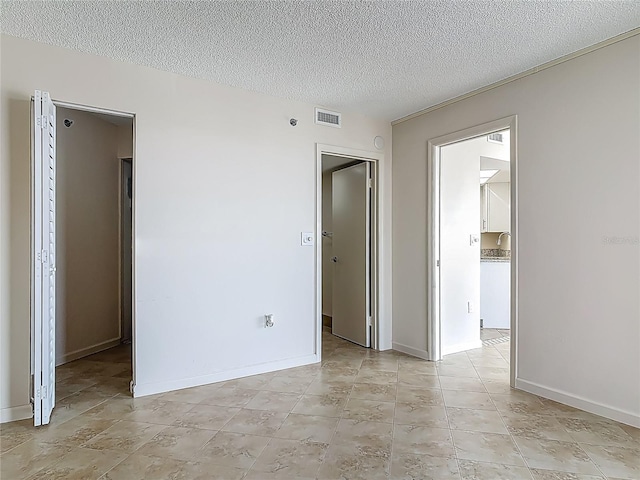 1 Oceans W Blvd Unit 2A1, Daytona Beach, FL 32118 - empty room with a textured ceiling, a sink, baseboards, and light tile patterned floors