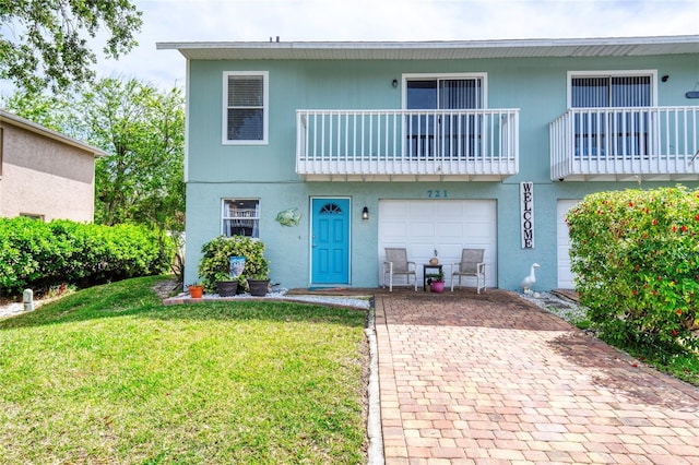 721 Laurel Bay Cir, New Smyrna Beach, FL 32169 - view of front facade featuring a front yard, decorative driveway, a balcony, and a garage