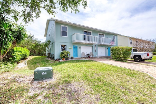 721 Laurel Bay Cir, New Smyrna Beach, FL 32169 - view of front facade with a balcony, a front lawn, driveway, and an attached garage