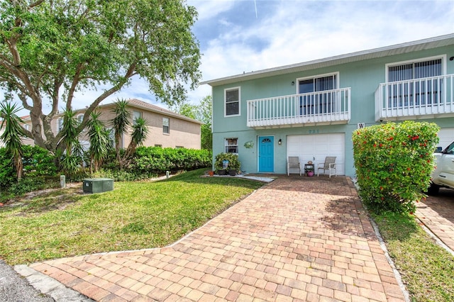 721 Laurel Bay Cir, New Smyrna Beach, FL 32169 - view of front of house featuring an attached garage, decorative driveway, a front yard, and a balcony