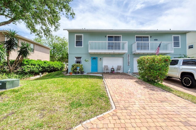 721 Laurel Bay Cir, New Smyrna Beach, FL 32169 - view of front of property with decorative driveway, a garage, a balcony, and a front lawn