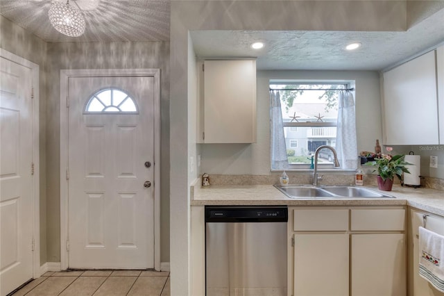 721 Laurel Bay Cir, New Smyrna Beach, FL 32169 - kitchen with dishwasher, a sink, light tile patterned floors, light countertops, and white cabinetry
