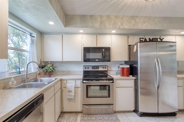 721 Laurel Bay Cir, New Smyrna Beach, FL 32169 - kitchen with appliances with stainless steel finishes, a sink, light countertops, light tile patterned flooring, and a textured ceiling