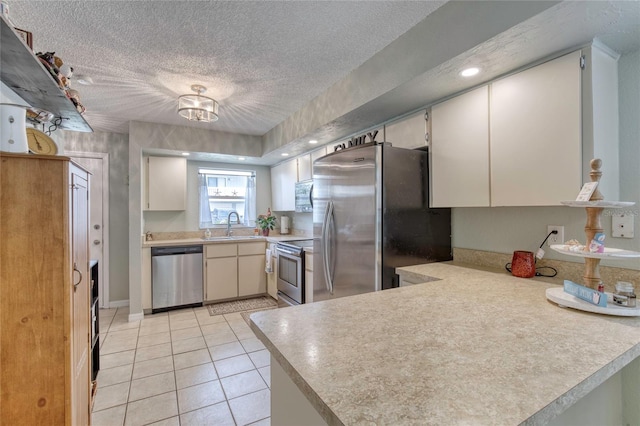 721 Laurel Bay Cir, New Smyrna Beach, FL 32169 - kitchen with appliances with stainless steel finishes, light countertops, a textured ceiling, a peninsula, and a sink
