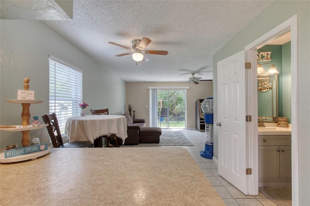 721 Laurel Bay Cir, New Smyrna Beach, FL 32169 - bedroom with access to exterior, a textured ceiling, light tile patterned floors, a sink, and connected bathroom