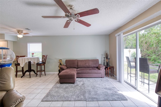 721 Laurel Bay Cir, New Smyrna Beach, FL 32169 - living area featuring light tile patterned flooring, a textured ceiling, a ceiling fan, and baseboards