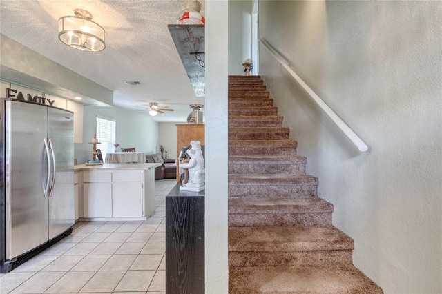 721 Laurel Bay Cir, New Smyrna Beach, FL 32169 - staircase featuring tile patterned floors, a textured wall, ceiling fan, and a textured ceiling