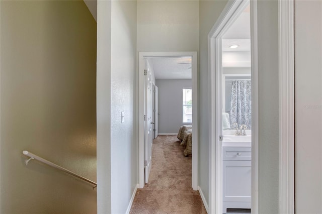 721 Laurel Bay Cir, New Smyrna Beach, FL 32169 - hallway featuring light colored carpet, baseboards, an upstairs landing, and a sink