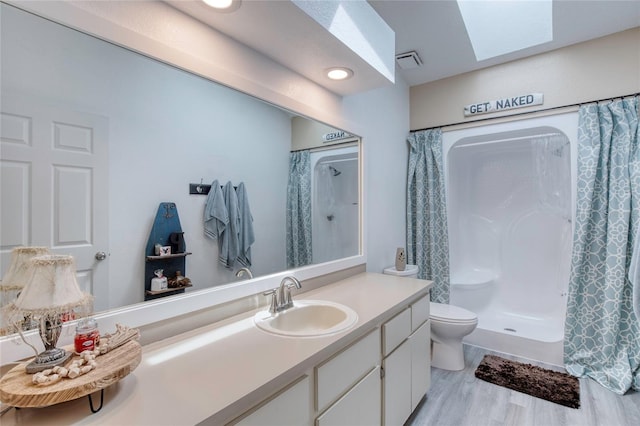 721 Laurel Bay Cir, New Smyrna Beach, FL 32169 - bathroom with a skylight, vanity, toilet, a shower with shower curtain, and wood finished floors