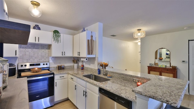 940 Village Trl Unit 8-205, Port Orange, FL 32127 - kitchen with stainless steel appliances, a peninsula, white cabinets, backsplash, and light stone counters