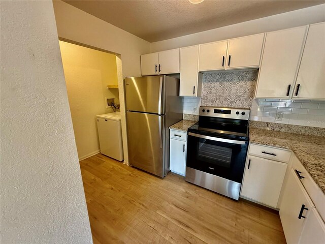 940 Village Trl Unit 8-205, Port Orange, FL 32127 - kitchen with stainless steel appliances, backsplash, washing machine and dryer, light wood-type flooring, and a textured wall