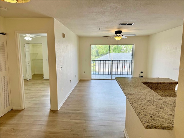 940 Village Trl Unit 8-205, Port Orange, FL 32127 - unfurnished dining area featuring ceiling fan, light wood-style floors, and a textured ceiling