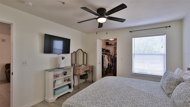 940 Village Trl Unit 8-205, Port Orange, FL 32127 - bedroom with multiple windows, a walk in closet, light wood-style flooring, and ceiling fan