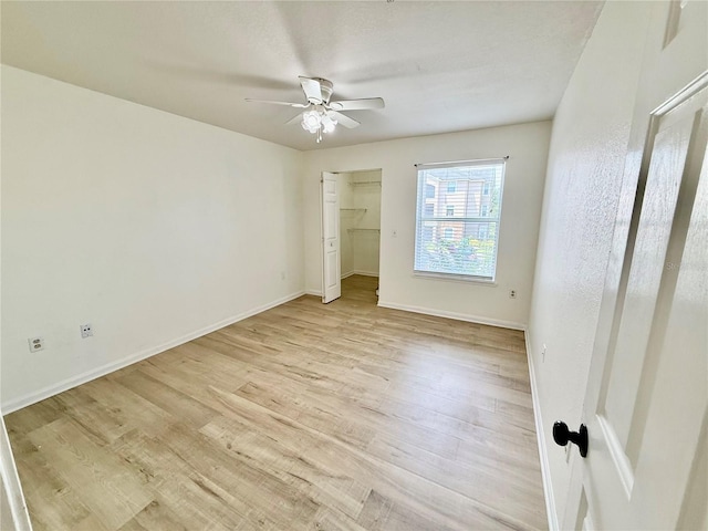 940 Village Trl Unit 8-205, Port Orange, FL 32127 - unfurnished bedroom with light wood-style flooring, a ceiling fan, and a closet