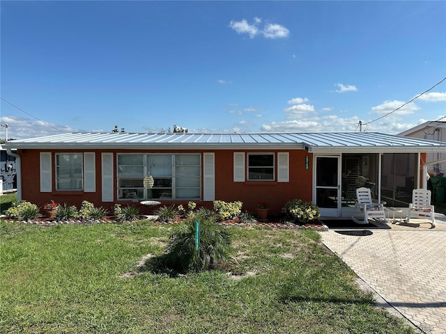 29146 Tamayo Dr, Punta Gorda, FL 33982 - back of house with a standing seam roof, a yard, a sunroom, metal roof, and stucco siding