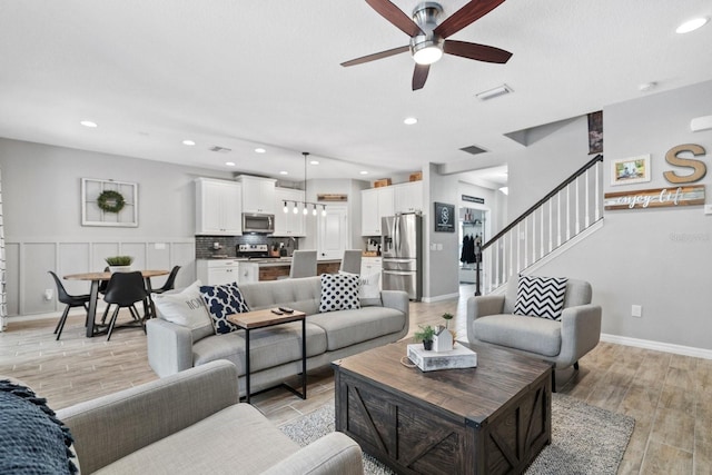 7114 Mill Hopper Ct, Palmetto, FL 34221 - living room with a ceiling fan, stairs, light wood finished floors, recessed lighting, and baseboards