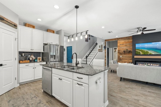 7114 Mill Hopper Ct, Palmetto, FL 34221 - kitchen with appliances with stainless steel finishes, a sink, wooden walls, ceiling fan, and recessed lighting