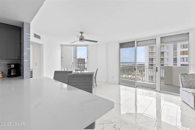 3047 S Atlantic Ave Unit 1805, Daytona Beach, FL 32118 - kitchen with plenty of natural light, a ceiling fan, floor to ceiling windows, open floor plan, and marble finish flooring