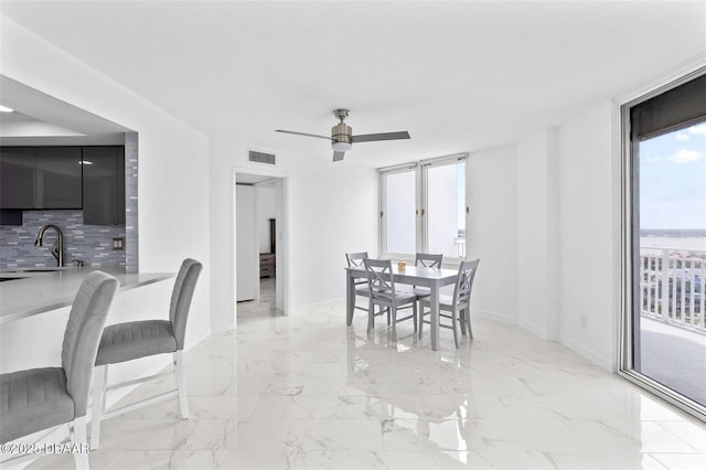 3047 S Atlantic Ave Unit 1805, Daytona Beach, FL 32118 - dining area featuring plenty of natural light, baseboards, a ceiling fan, and light marble finish floors