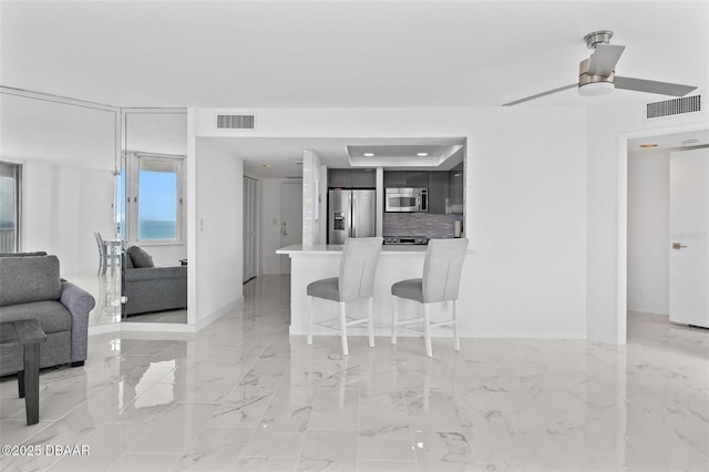 3047 S Atlantic Ave Unit 1805, Daytona Beach, FL 32118 - kitchen featuring appliances with stainless steel finishes, a kitchen bar, open floor plan, baseboards, and light countertops