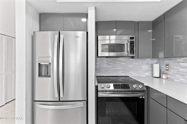 3047 S Atlantic Ave Unit 1805, Daytona Beach, FL 32118 - kitchen with stainless steel appliances, gray cabinets, backsplash, modern cabinets, and light countertops