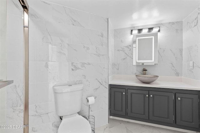 3047 S Atlantic Ave Unit 1805, Daytona Beach, FL 32118 - bathroom featuring vanity, tile walls, toilet, and marble finish floors