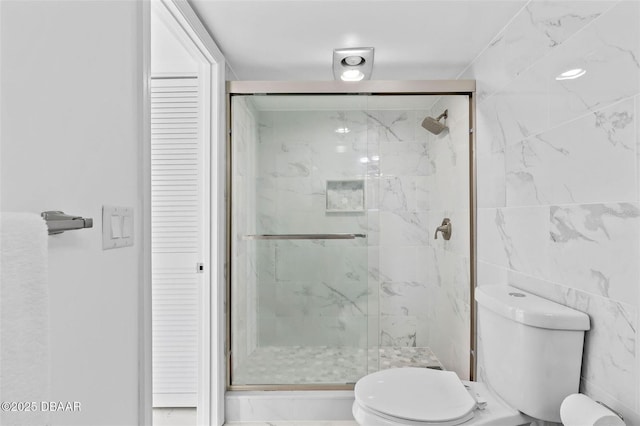 3047 S Atlantic Ave Unit 1805, Daytona Beach, FL 32118 - bathroom featuring toilet, a closet, a marble finish shower, and tile walls