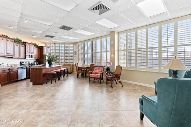 3047 S Atlantic Ave Unit 1805, Daytona Beach, FL 32118 - living area with a paneled ceiling, light tile patterned floors, and baseboards