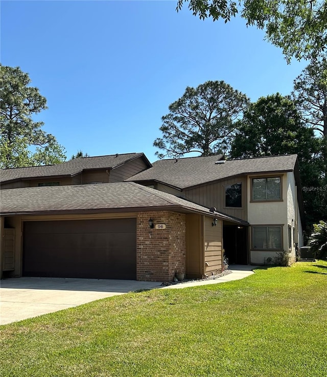 96 Old Barn Trl, Ormond Beach, FL 32174 - view of property with a garage, roof with shingles, a front lawn, driveway, and brick siding