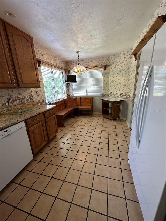 96 Old Barn Trl, Ormond Beach, FL 32174 - kitchen featuring wallpapered walls, white appliances, light tile patterned floors, a chandelier, and a textured ceiling