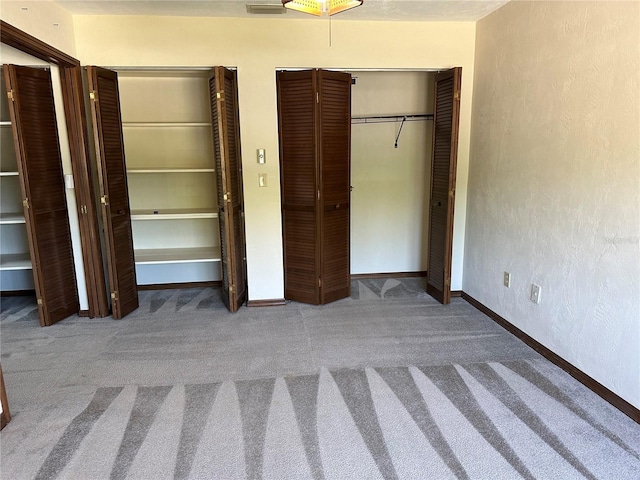 96 Old Barn Trl, Ormond Beach, FL 32174 - unfurnished bedroom featuring carpet, two closets, a textured wall, and baseboards