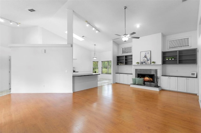 802 Royal Oak Ct, Deland, FL 32724 - unfurnished living room with track lighting, ceiling fan, a high end fireplace, light wood-type flooring, and high vaulted ceiling