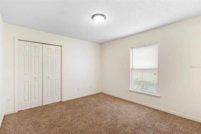 802 Royal Oak Ct, Deland, FL 32724 - unfurnished bedroom with carpet flooring, a closet, baseboards, and a textured ceiling