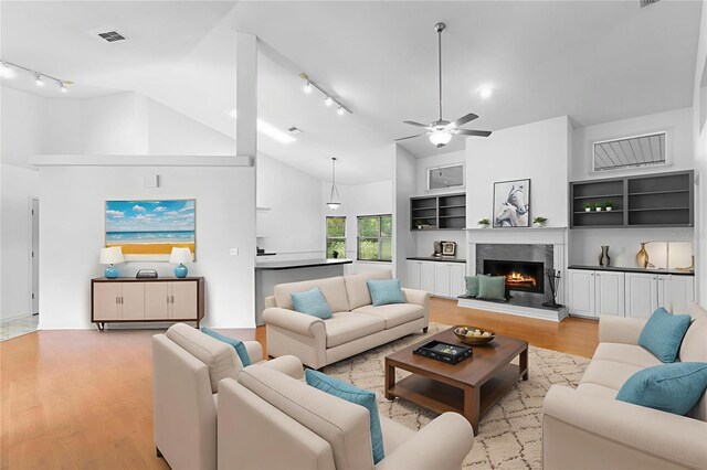 802 Royal Oak Ct, Deland, FL 32724 - living area with rail lighting, light wood-type flooring, ceiling fan, a premium fireplace, and high vaulted ceiling
