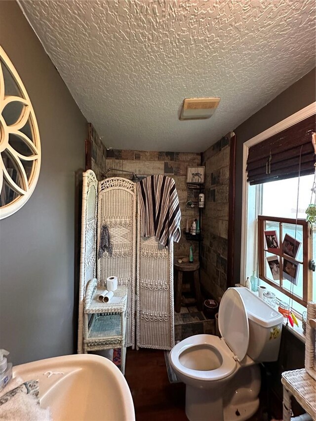 43721 State Road 19, Altoona, FL 32702 - bathroom with a textured ceiling, a tile shower, toilet, and wood finished floors