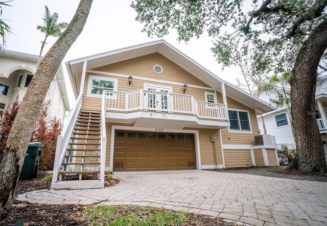 5169 Oxford Dr, Sarasota, FL 34242 - view of front of home with decorative driveway, a garage, a balcony, and stairway