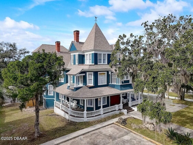 404 S Ridgewood Ave, Daytona Beach, FL 32114 - victorian house with a porch, a shingled roof, and a chimney