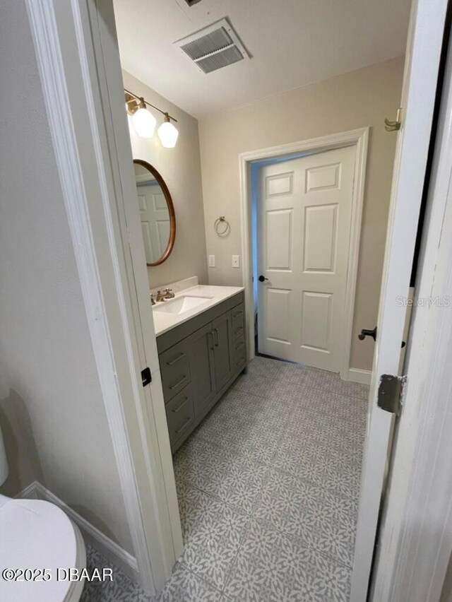 404 S Ridgewood Ave, Daytona Beach, FL 32114 - bathroom with vanity, toilet, and baseboards