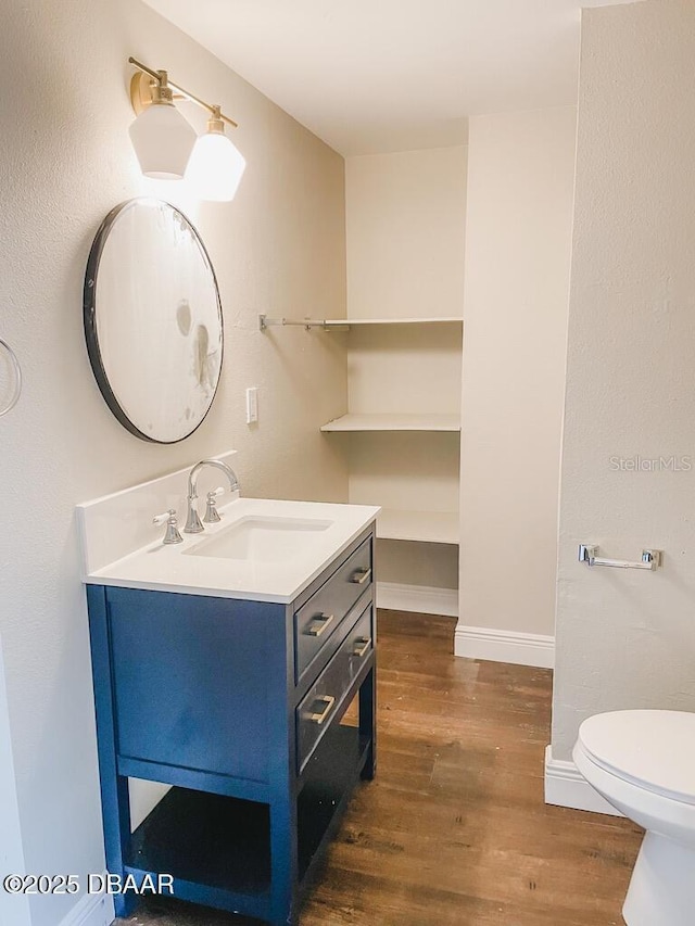 404 S Ridgewood Ave, Daytona Beach, FL 32114 - bathroom with vanity, wood finished floors, toilet, and baseboards