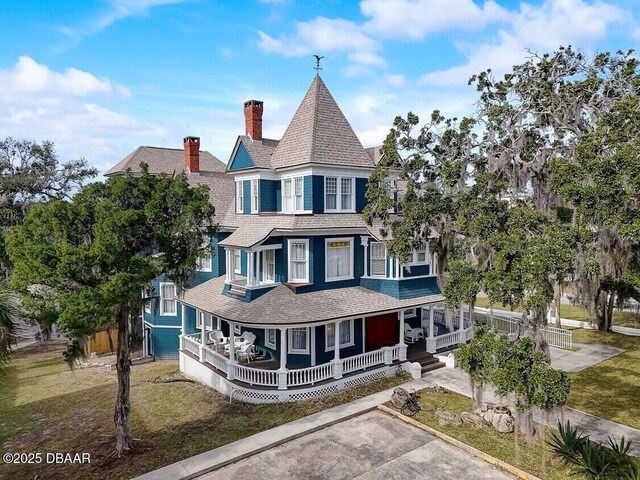 404 S Ridgewood Ave, Daytona Beach, FL 32114 - victorian house with a porch, a shingled roof, and a chimney