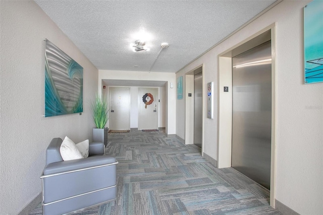3043 S Atlantic Ave Unit 204, Daytona Beach, FL 32118 - hallway with elevator, a textured ceiling, carpet flooring, and baseboards
